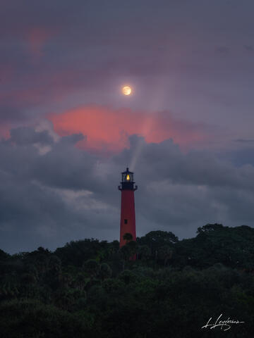 Glowing moon rising over the ocean at twilight near Jupiter, Florida.