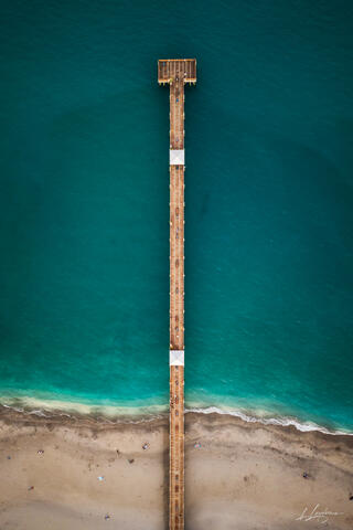 Aerial top-down vertical photograph of the Juno Beach Pier showing geometric symmetry over the turquoise ocean in Jupiter / Juno Beach, Palm Beach County, Flori