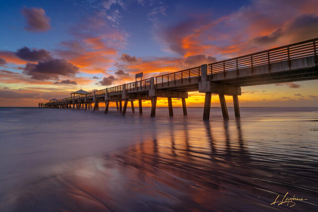 Abstract sunrise reflection on wet sand, Juno Beach.