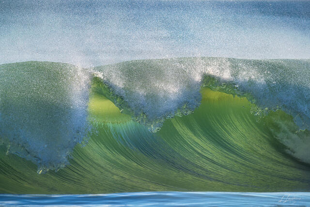 Close-up photograph of a breaking wave glowing in morning sunlight along the Juno Beach shoreline. Fine art ocean photography by Lawrence Leyderman.
