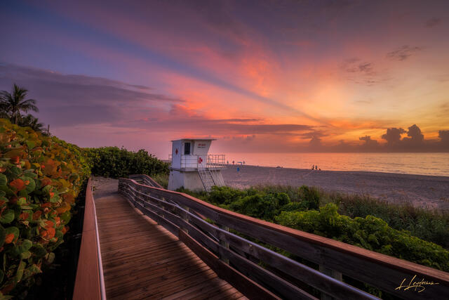 Sunrise over a white lifeguard tower on the Beach.