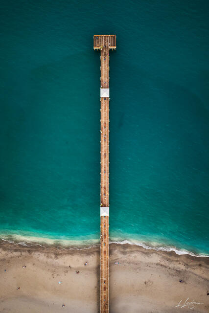 Aerial top-down vertical photograph of the Juno Beach Pier showing geometric symmetry over the turquoise ocean in Jupiter / Juno Beach, Palm Beach County, Flori