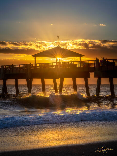 Soft pastel sunrise with ocean reflections at Juno Beach Pier.