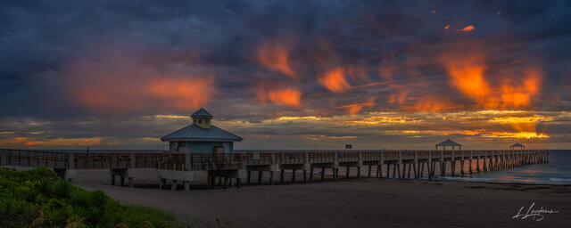 Virga clouds glowing at sunset above the ocean near Juno Beach Pier.