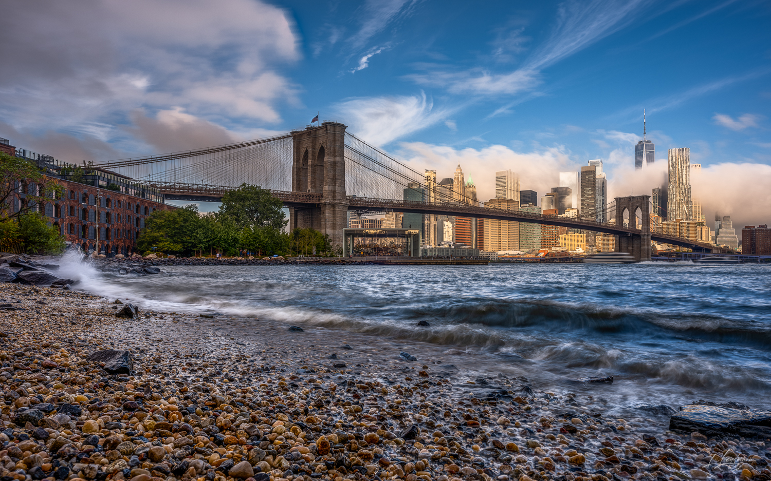 The Brooklyn Bridge stands as a steadfast passage to the bustling skyline, while the waters of the East River lap rhythmically...