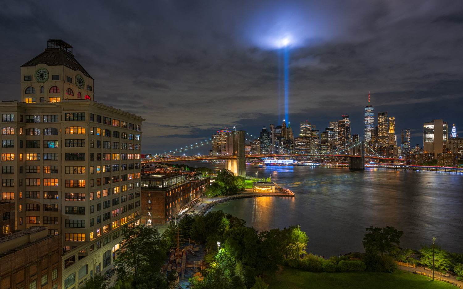 From Dumbo's shore, we cast our gaze,Brooklyn Bridge, through nighttime haze,9/11's lights pierce the night,A cloud embraced...