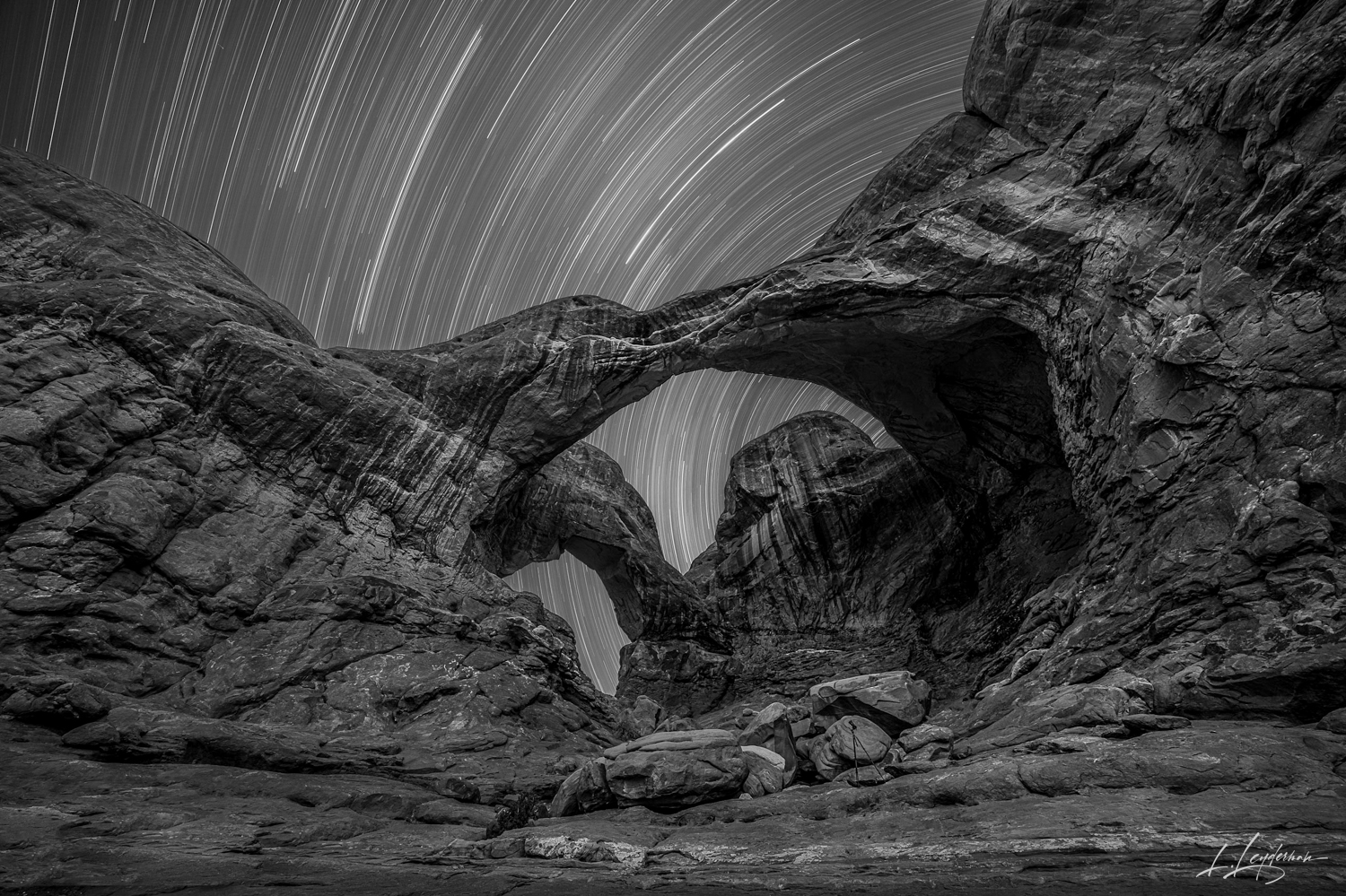 Earth and sky converge in this sculpture of night, where the rock arch gives shape to the intangible journey of stars, etching...