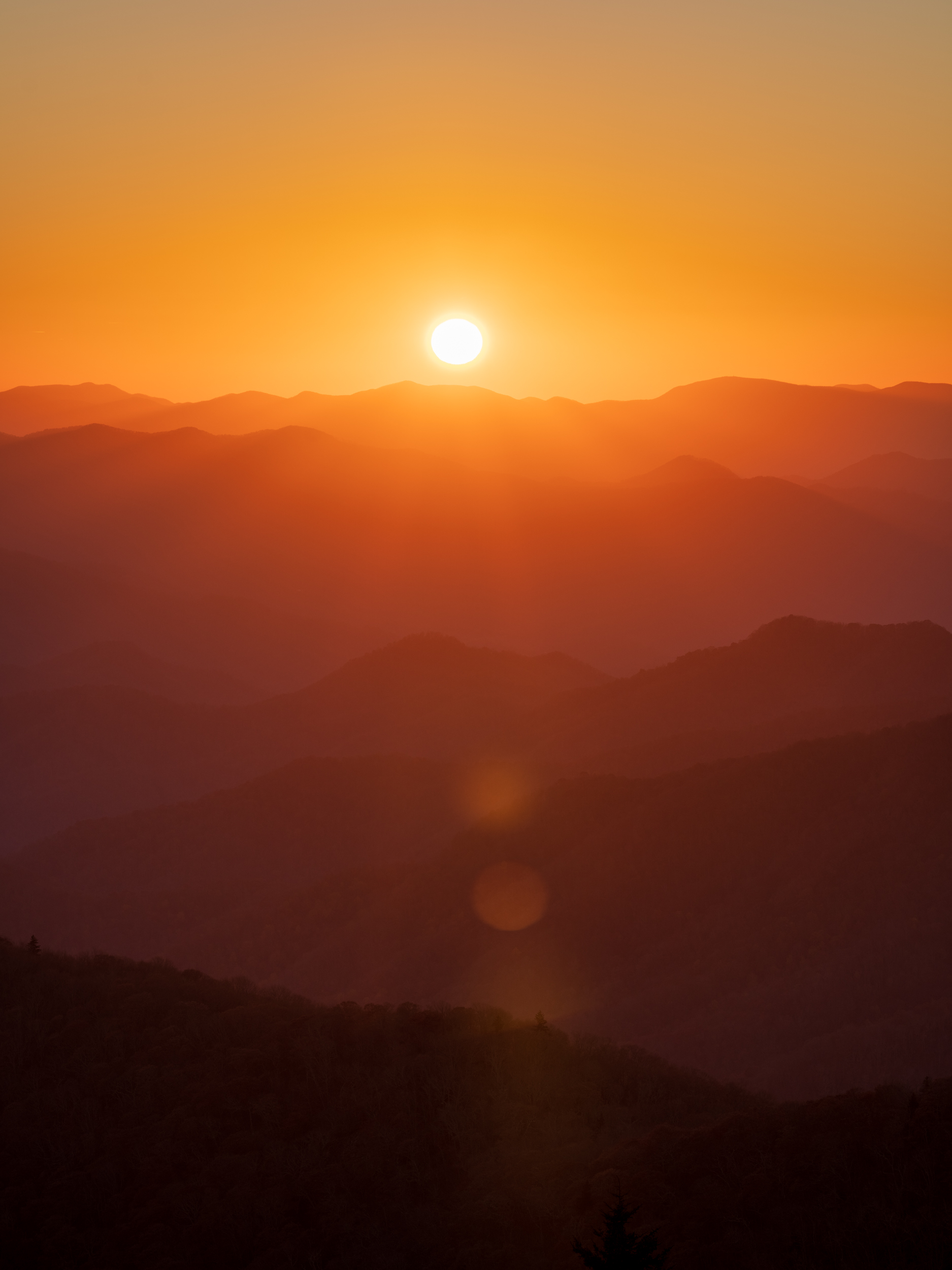 A symphony of light plays across the sky, announcing the morning over the Blue Ridge Mountains. The soft golden hues create a...