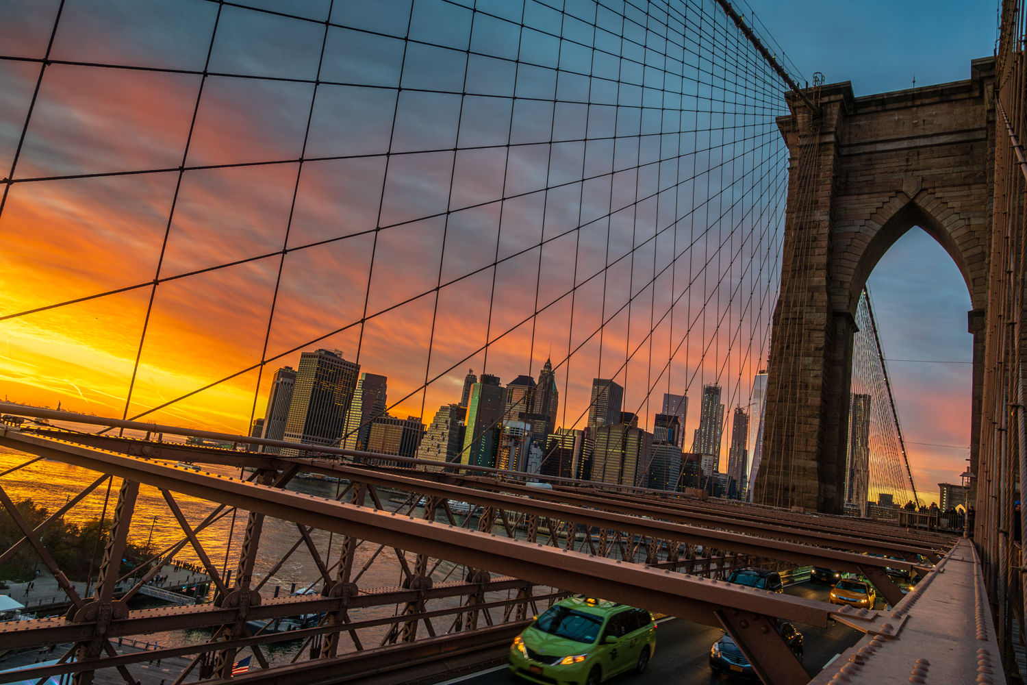 Fiery skies in twilight's dance,Brooklyn Bridge, a fleeting glance,Manhattan's lights begin to gleam,A taxi's journey through...